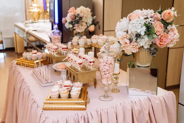 Choklad kaka på bord i vas och tallrik, makaroner, marshmallow, tårta och cupcake — Stockfoto