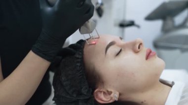 Yavaş hareket kozmetolog eller özel cihaz ile kız yüz soyma yapmak