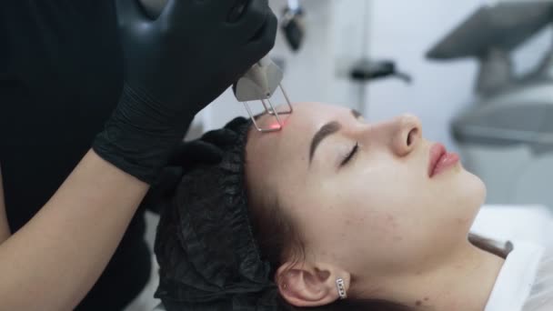 Las manos cosmetólogas de cámara lenta hacen que la chica se pele la cara con un dispositivo especial — Vídeo de stock