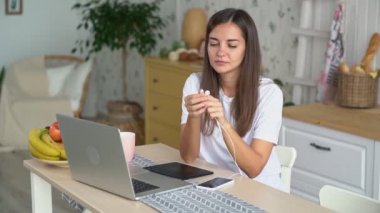 Kız laptop çalışır, kulaklıkları koyar ve telefonda müzik açar, yavaş hareket