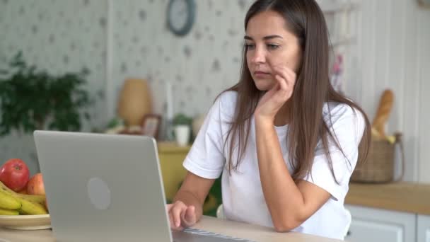 Portret zmęczonej dziewczyny działa na laptopie w domu i ma straszny ból głowy, powolny ruch — Wideo stockowe