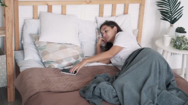 Девушка спит на кровати, просыпается от телефонного звонка, разговаривает и засыпает, замедленная съемка — стоковое видео