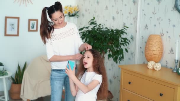 Moeder kammen en vlechten haar van dochter in pigtail, Slow Motion — Stockvideo