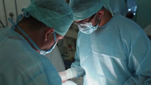 Команда врачей в стерильной одежде и маске во время операции. Медленное движение — стоковое видео