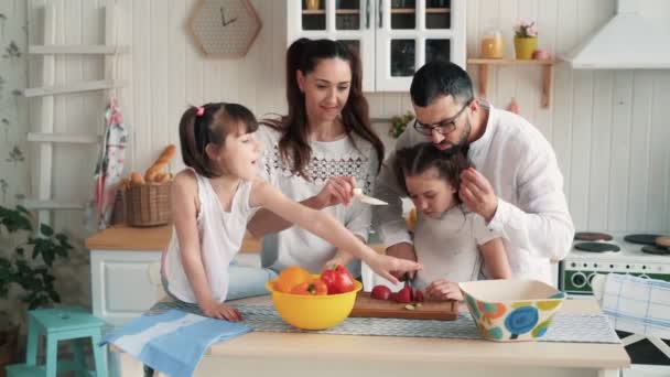 Lycklig familj förbereder mat på kök, skära grönsaker, slow motion — Stockvideo