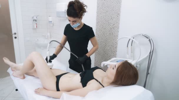 Mulher no cargo de esteticista faz procedimento anti-celulite nas pernas, câmera lenta — Vídeo de Stock