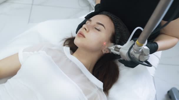 Верхний вид лица молодой женщины на лазерной процедуры пилинга лица, замедленная съемка — стоковое видео