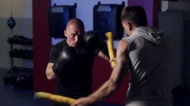 Koç spor salonunda boksör trenler, tekme ve savunma, yavaş hareket dışarı çalışmak.