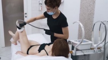 Güzellik uzmanı klinikte hasta vücudunda cilt sıkılaştırma işlemi yapar, yavaş hareket