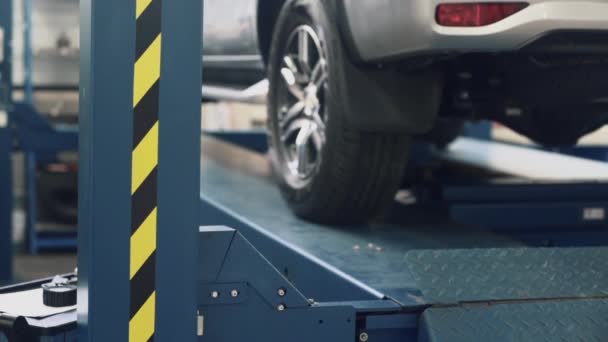 Närbild, lyfter bil på hiss i Auto Center, slow motion — Stockvideo