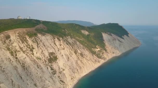 Filmagem aérea, parte da terra no mar, bela vista da colina gramada, câmera lenta — Vídeo de Stock