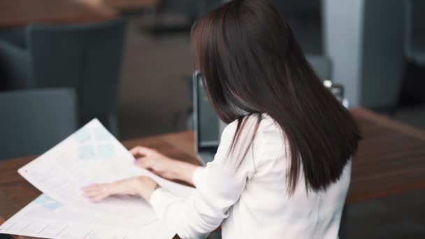 Achteraanzicht, meisje freelancer kijkt naar menu in café, laptop op tafel, Slow Motion — Stockvideo