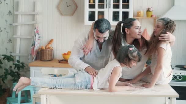 Eltern und Töchter in der Küche mit Mehl beschmutzt, lachen, spielen, Zeitlupe — Stockvideo