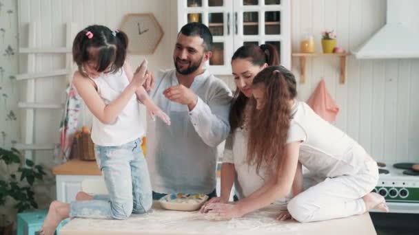 Счастливая семья приготовления пищи на кухне, мать готовит тесто для выпечки, замедленной съемки — стоковое видео