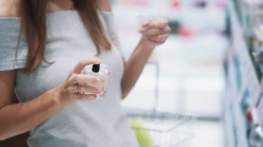  Pretty kız kozmetik dükkanında test parfüm püskürtülür, koklar, yavaş hareket