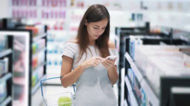 Ticaret katta güzel kız telefon kullanır, mobil ekran, yavaş hareket bakar