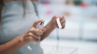 Kozmetik mağazasında test kız sprey parfüm, yavaş hareket ellerini kapatın