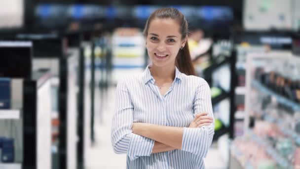 Retrato de chica en la tienda de cosméticos sonriendo y mirando a la cámara, cámara lenta — Vídeos de Stock