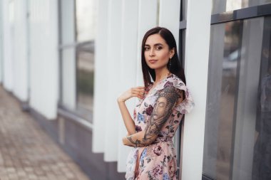 İş merkezi yakınında poz renkli elbise çekici esmer kız.