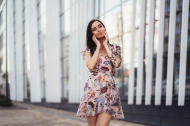 İş merkezi yakınında poz renkli elbisegüzel genç kadın