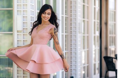 Sokak kafede poz pembe elbise güzel gülümseme ile sevimli model