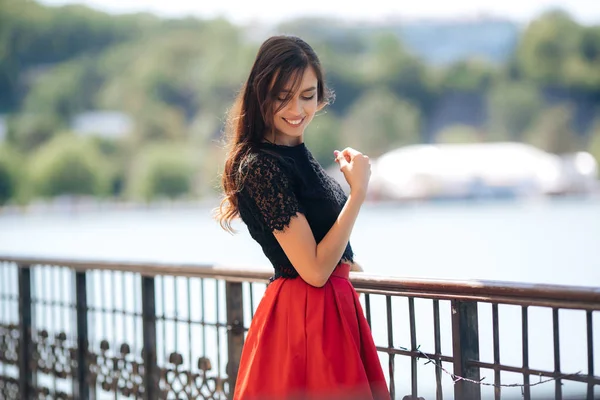 Menina feliz bonita posando ao ar livre usando saia vermelha e blusa preta — Fotografia de Stock