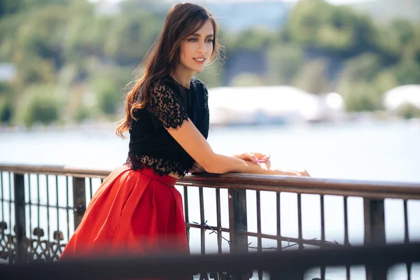 Hermosa chica feliz posando al aire libre con falda roja y blusa negra — Foto de Stock