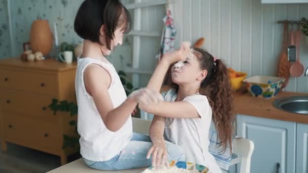 Små flickor kastar mjöl på varandra, ha kul tid på kök, slow motion — Stockvideo