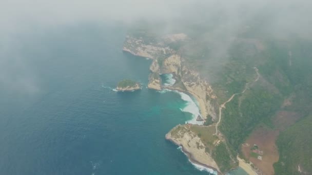 Letecký pohled na modrý oceán, vlny, tropický ostrov s horami přes mraky — Stock video