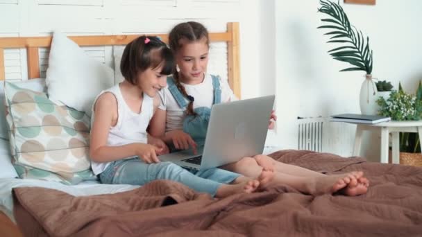 Маленькие девочки смотрят что-то на ноутбуке и эмоционально обсудить это, замедленная съемка — стоковое видео