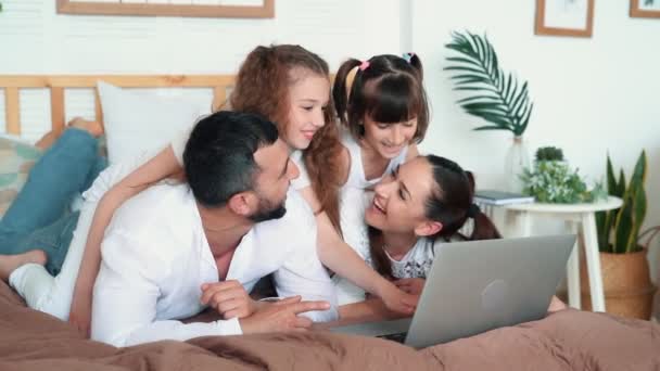 Pappa, Mamma och två döttrar spelar i datorspel på laptop, slow motion — Stockvideo