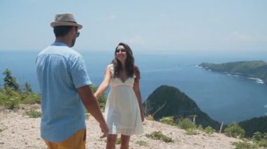 Erkek ve kız birbirlerine el tutun, okyanusun güzel görünümü, yavaş hareket hayran