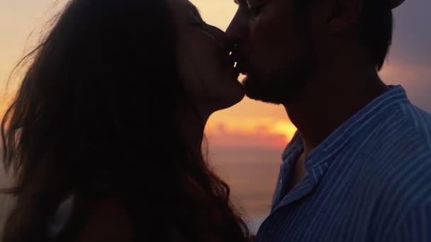 Silhueta de homem e mulher abraçando, beijando no fundo do pôr do sol, câmera lenta — Vídeo de Stock