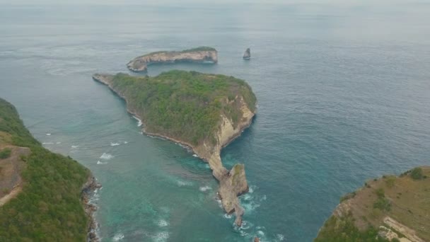 Вид с воздуха на остров, скалы, голубая вода океана и волны, Бали, Индонезия — стоковое видео