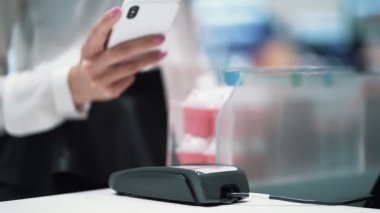 Yakın kadın el telefon kullanarak mal için öder, temassız ödeme, yavaş hareket
