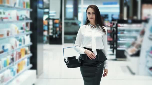 Belle fille va au magasin de cosmétiques avec panier, ralenti, steadicam shot — Video