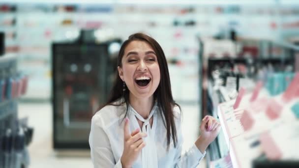 Mooi meisje shopper lacht en glimlacht in cosmeticawinkel, Slow Motion — Stockvideo