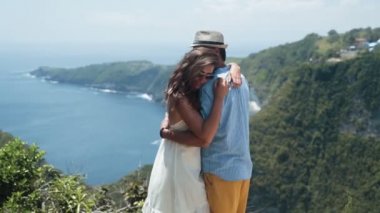 Aşıklar dağdan okyanusun güzel görünümü arka planda sarılmak, yavaş hareket