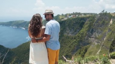 Aşıklar çift birbirlerine el tutun, okyanus güzel görünümü hayran, yavaş hareket