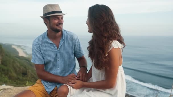 Os amantes se sentam no lugar romântico, manter as mãos juntas, câmera lenta — Vídeo de Stock