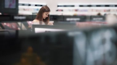 Alışveriş merkezinde Güzel kız kozmetik eşya, yavaş hareket seçer