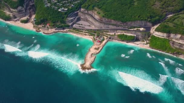 Vista aérea da praia com ondas marinhas turquesa, estrada, moradias no penhasco em verde — Vídeo de Stock