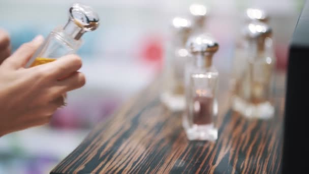 Close-up de perfume em vitrine, mão do comprador menina leva, câmera lenta — Vídeo de Stock