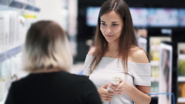 Compratore ragazza parlando con assistente negozio in negozio di cosmetici, rallentatore — Video Stock