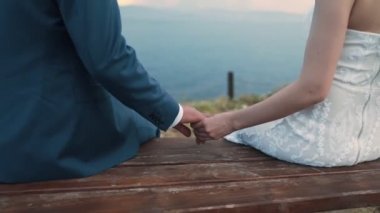 Yakın yeni evliler el ele tutuşup salıncakta salıncak, düğün günü