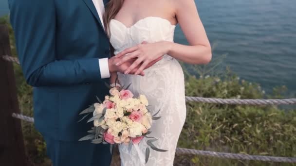 Gros plan main de mariée coups main de marié, mer sur le fond, ralenti — Video
