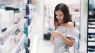 Kozmetik dükkanındakadın duş jeli seçer, etiket okur, koklar, yavaş hareket