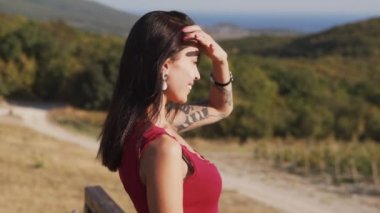 Kadın mesafeye bakar, birini bekler, arka planda alanlar, yavaş çekim