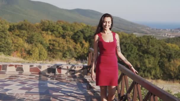 Kvinna går till kamera, leenden, vacker utsikt över naturen på bakgrunden, slow motion — Stockvideo