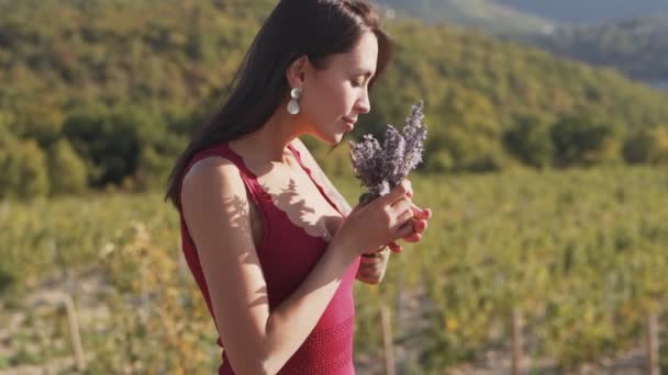 Mulher bonita segura buquê de flores silvestres e fareja-los, câmera lenta — Vídeo de Stock